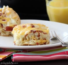 two breakfast pastries on a white plate with orange juice in the background