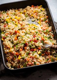 a pan filled with rice and vegetables on top of a table