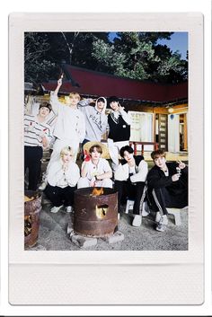 a group of young people posing for a photo in front of a small building at night