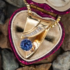 This lovely 14K yellow gold slide pendant is accented with one (1) round mixed cut natural tanzanite set into a six-prong setting and eleven (11) baguette cut diamonds set into a channel. The pendant measures 23.3mm X 13.1mm X 10.6mm and is suspended from a box chain measuring 1.8mm wide and 22 inches in length. The chain is finished with a lobster clasp. Gold Tanzanite Jewelry With Bezel Setting, Luxury Tanzanite Necklace With Brilliant Cut, Luxury Gold Tanzanite Necklace, Yellow Gold Tanzanite Pendant Necklace, Luxury Tanzanite Pendant Jewelry, Eleven 11, Gold Slides, Baguette Cut Diamond, Natural Tanzanite