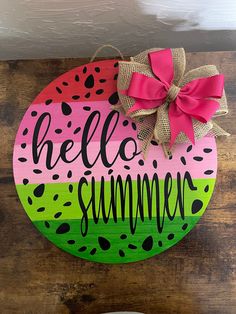 a painted wooden sign that says hello summer with a pink bow on the front and green watermelon design