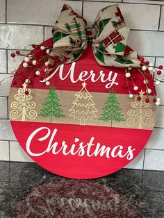 a merry christmas sign hanging from the side of a brick wall