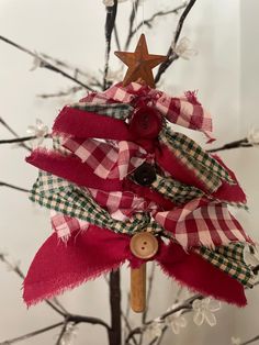 a small christmas tree decorated with red and green plaid ribbon, wooden star on top