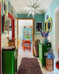 the hallway is decorated in bright colors with pictures on the walls and ceiling fan above it