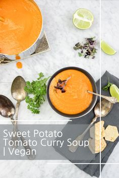 sweet potato tomato curry soup / vegan with spoons and lime on the side