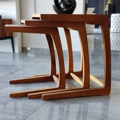 three wooden tables sitting on top of a marble floor