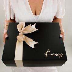 a woman is holding a fancy black box