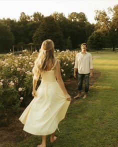 a man and woman are walking in the grass