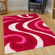 a red and white rug in a living room next to a chair with a blue pillow