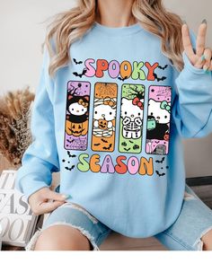 Get ready to embrace the spooky season with our Hello Kitty Spooktacular Sweater! Featuring your favorite feline in a Halloween-themed design, this cozy sweater combines cute and creepy with Hello Kitty surrounded by ghosts, pumpkins, and bats. Perfect for fans who love a dash of spooky with their style, this sweater will keep you warm and stylish all autumn long. Made from high-quality materials, it's as comfortable as it is charming. Whether you're trick-or-treating or just enjoying a chilly f Fall Kawaii Style Sweatshirt With Cartoon Print, Kawaii Cartoon Print Sweatshirt For Fall, Playful Cartoon Print Sweater For Fall, Fall Hello Kitty Long Sleeve Top, Hello Kitty Print Long Sleeve Top For Fall, Kawaii Crew Neck Sweater For Fall, Cute Long Sleeve Hello Kitty Sweatshirt, Cute Fall Sweatshirt With Character Print, Trendy Fall Sweatshirt With Cat Design