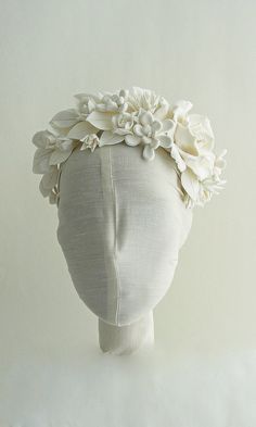 a white mannequin head with flowers on it