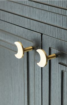 an image of two door knobs on the side of a cabinet that is painted gray and gold