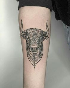 a bull's head tattoo on the leg