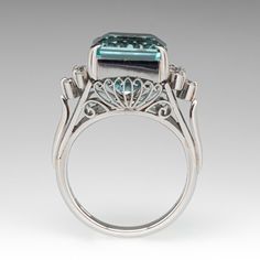 This gorgeous vintage ring is centered with one (1) emerald cut aquamarine that is set into a four-prong setting. On either side of the aquamarine are five (5) round brilliant cut diamonds that are prong set. The side galleries of the ring have ornate filigree designs. The ring measures 12.1mm at the top, rises 10.6mm above the finger, tapering to 2.9mm wide and 1.6mm thick at the base of the shank. It is currently a size 6 with a knife edge shank. Elegant Emerald-cut Topaz Rings, Aquamarine Brilliant Cut Diamond Ring For Formal Occasions, Octagon Emerald Ring With Diamond Accents For Formal Events, Formal Aquamarine Diamond Ring With Brilliant Cut, Octagonal Emerald Ring With Diamond Accents For Formal Events, Luxury White Gold Topaz Ring Emerald Cut, Formal Octagon Emerald Ring With Diamond Accents, Elegant Octagon Topaz Ring With Center Stone, Elegant Octagon Topaz Ring For Wedding