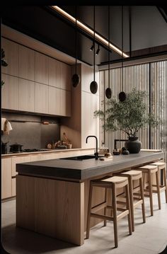 an island in the middle of a kitchen with stools and a potted plant