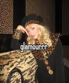 a woman wearing a leopard print scarf and black hat with the words glamour on it