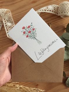 a hand holding a card with flowers on it