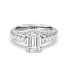 a diamond engagement ring with two bands around the band and an emerald cut center stone