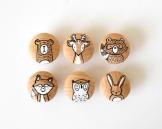 six wooden buttons with animals on them sitting next to each other in front of a white background