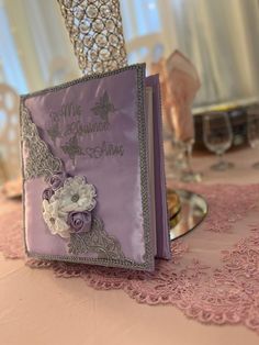 a purple book with flowers on it sitting on top of a table