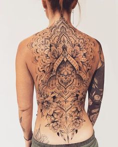 the back of a woman's body with tattoos on her upper and lower half