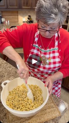 a woman in an apron mixing food into a bowl