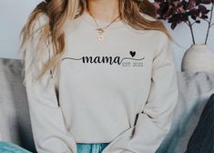 Mama(or your custom name) Est (your custom year) Unisex Sweatshirt Color pictured is a sand sweatshirt with black vinyl. Thank you for shopping Sweet Caroline Co! Please read full description for everything you need to know about ordering your new shirt. T-shirts are unisex and super soft Gildan Brand. Please see size chart before ordering. When in doubt, size up for room to grow and possible shrinking of fabric. Want a snugger fit? Shirts are unisex, so size down. Need a larger size than 2XL? I White Crew Neck Top With Custom Name, Custom Name Tops For Mother's Day Gift, Custom Text Long Sleeve Tops For Gifts, Custom Text Long Sleeve T-shirt For Mother's Day, Personalized Long Sleeve Tops With Custom Text, Personalized Crew Neck Top, Casual Custom Name Tops For Gifts, Casual Custom Name Top For Gift, Personalized Long Sleeve T-shirt With Letter Print