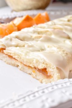 a close up of food on a plate with carrots and bread in the background