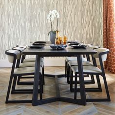 a dining room table with chairs and plates on it