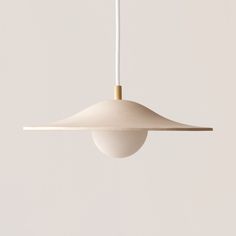 a white light hanging from a ceiling with a wooden stick sticking out of it's end