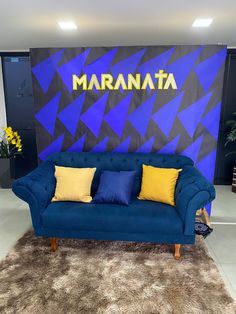 a blue couch sitting on top of a shaggy rug in front of a large wall