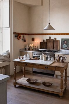 a kitchen with an old fashioned stove and wooden table in it's center area