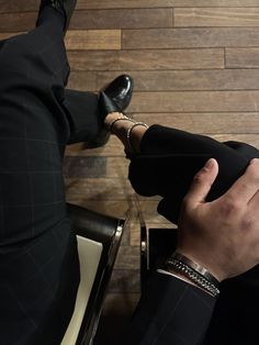 a man in a suit and tie sitting down with his feet on a chair