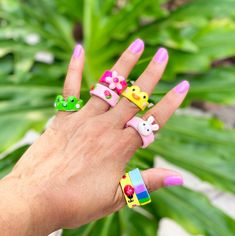 a person's hand with four different rings on it and one has an animal