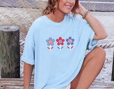 Retro Flowers 4th Of July t-shirt. These tees are Comfort Colors and are made to last using premium ringspun cotton, this creates an vintage-soft shirt. The soft-washed, garment-dyed fabric brings extra coziness to your wardrobe while the relaxed fit makes it an excellent daily choice. ✦ 100% Ringspun Cotton ✦ Relaxed fit ✦ Medium fabric ✦ Sewn-in twill label ✦ Eco-friendly, Ethically Made & Sweatshop Free ✦ Printed to order with non-toxic ink ✦ Durable and Long-lasting ✦ Shirts are pre-shrunk b Patriotic Crew Neck T-shirt For Spring, Blue Patriotic T-shirt For Spring, Patriotic Crew Neck Shirt For Spring, Spring Patriotic Crew Neck Shirt, Spring Patriotic T-shirt With Relaxed Fit, Patriotic Relaxed Fit T-shirt For Spring, Patriotic Relaxed Fit Top For Spring, Relaxed Fit Patriotic Top For Spring, Patriotic Relaxed Fit Shirt For Spring