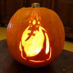 a carved pumpkin sitting on top of a wooden table