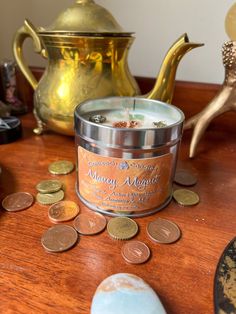 a candle sits on a table next to some coins