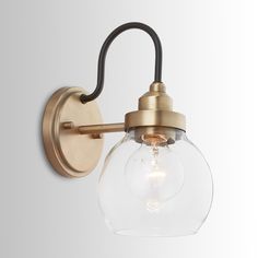 an antique brass wall light with clear glass globe shade