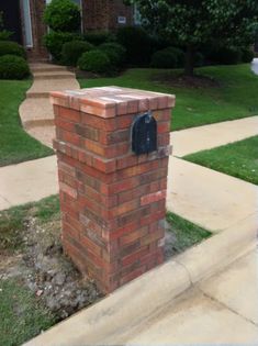 a brick mailbox in front of a house