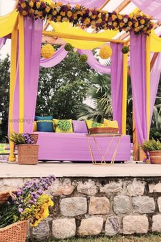 an outdoor seating area with purple and yellow decor