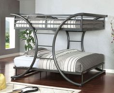 a metal bunk bed sitting on top of a hard wood floor next to a window