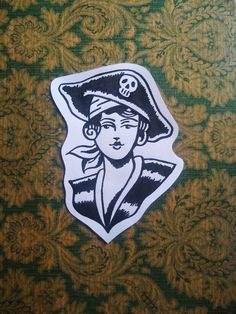 a sticker depicting a woman with a pirate hat and skull on her head is shown