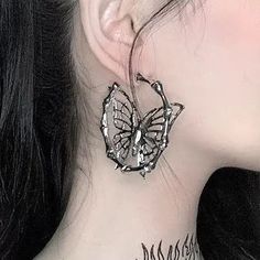 a close up of a person with a butterfly tattoo on their neck and behind her ear