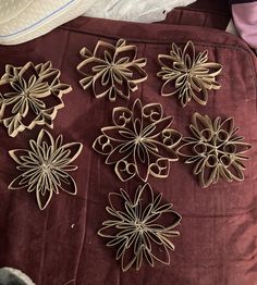 several pieces of wood carved to look like flowers on a red velvet bed spreader