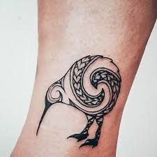 a black and white bird tattoo on the ankle