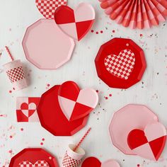 valentine's day table setting with red and white plates, napkins, paper fans and cups