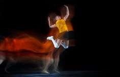 a blurry photo of two people playing with a frisbee in the dark