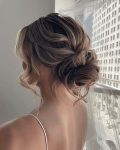 the back of a woman's head with her hair in a low bun