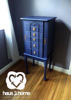 a blue chest of drawers in a room with wood flooring and gray wall behind it