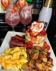 the breakfast is ready to be eaten on the table in the kitchen, with two glasses of pink lemonade and strawberries